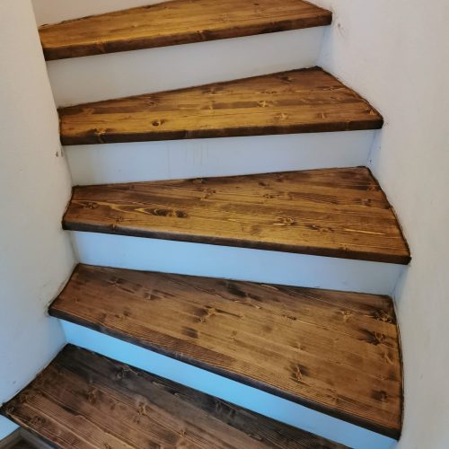 Renovierte Holztreppe mit massiven Holzstufen nach Treppenrenovierung durch RTR Bodenleger nahe Wien