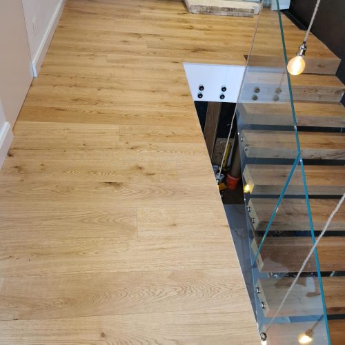 Verlegter Eichenparkettboden mit moderner Holztreppe und Glasgeländer durch RTR Bodenleger nahe Wien
