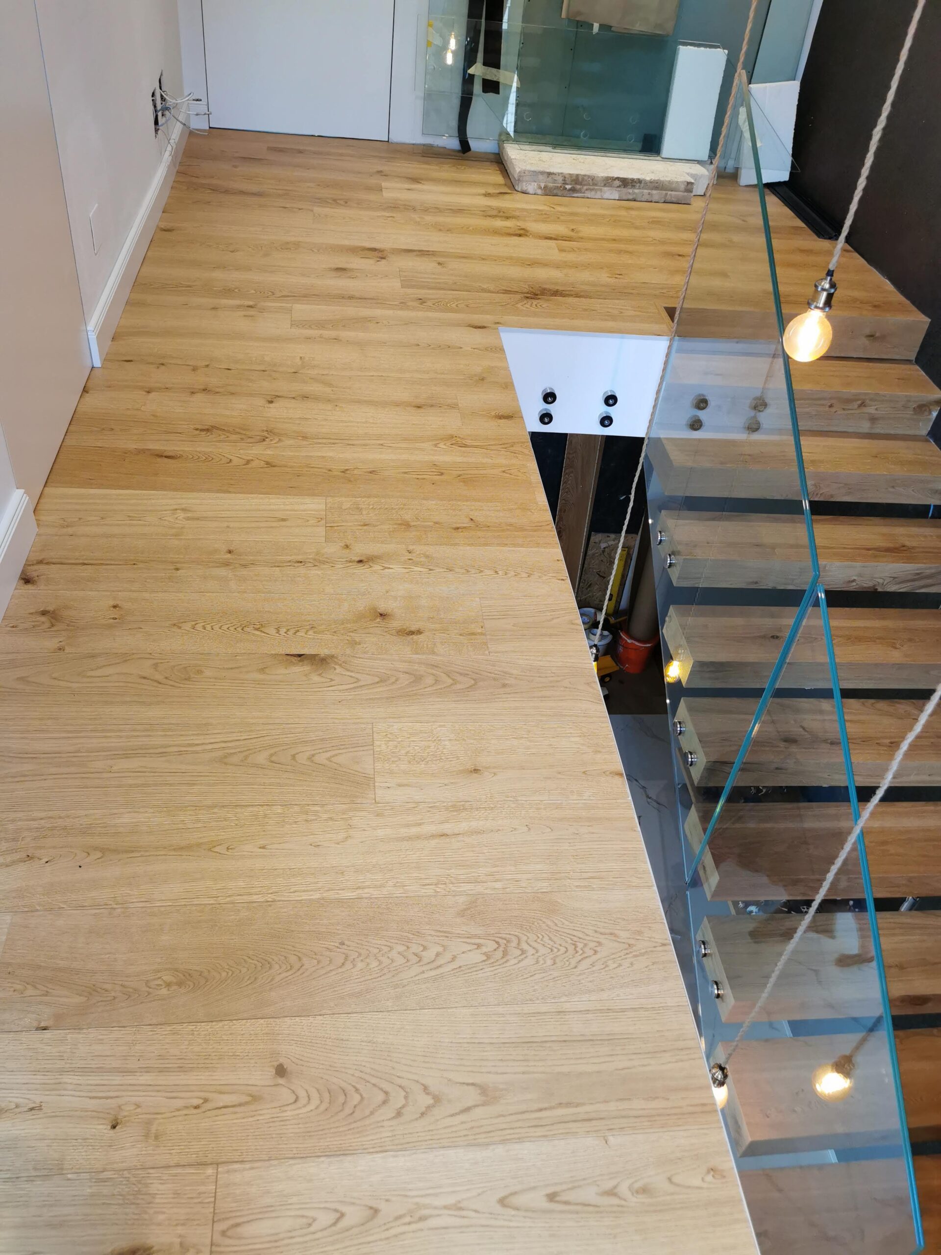 Verlegter Eichenparkettboden mit moderner Holztreppe und Glasgeländer durch RTR Bodenleger nahe Wien